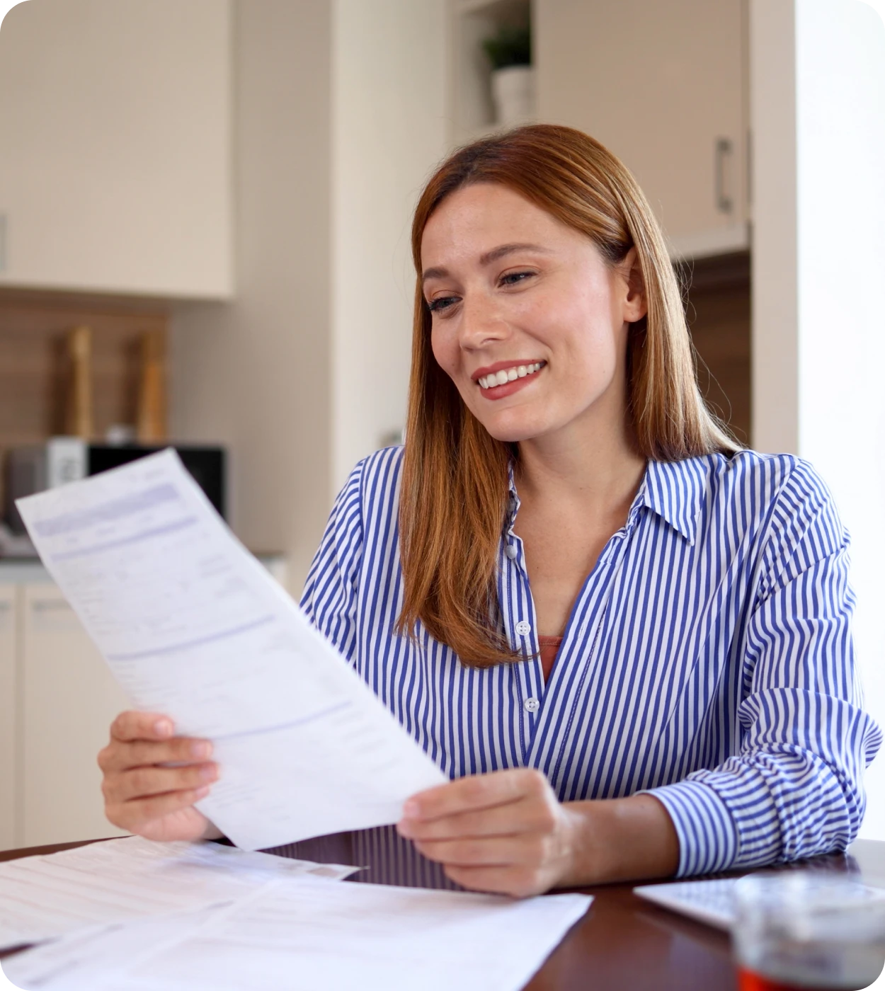 Woman smiling while reading a document.